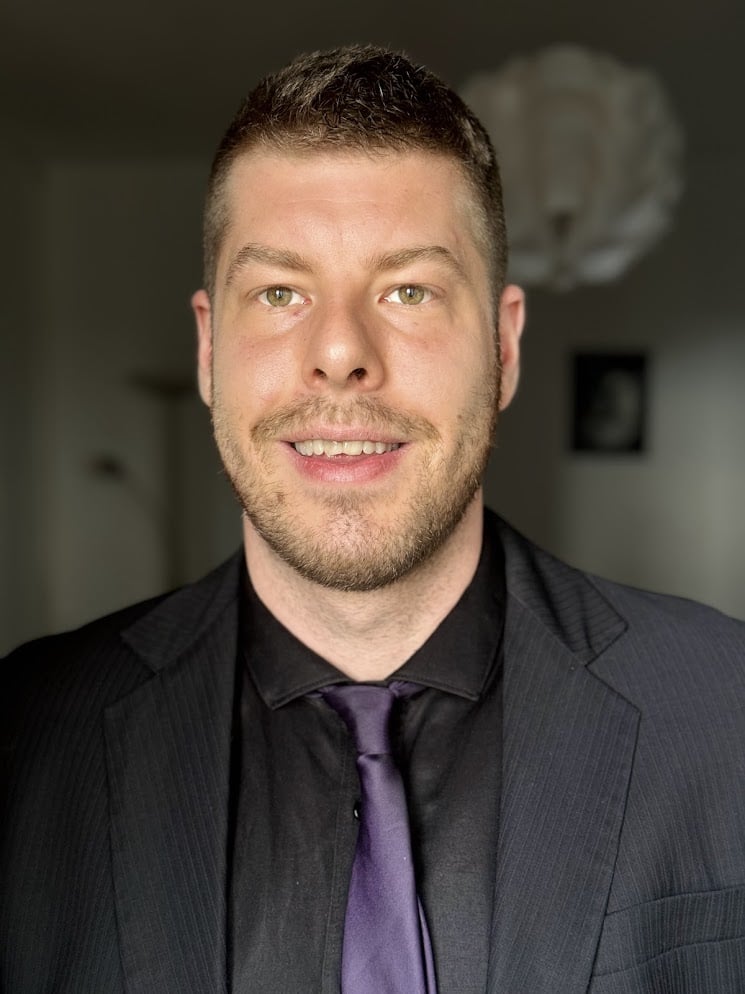 Professional headshot—Nick RevOps strategist in suit and purple tie; HubSpot, healthcare, e-commerce growth.